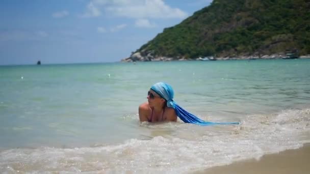 Mädchen liegt am Strand und genießt die Meereswellen an einem sonnigen Tag — Stockvideo