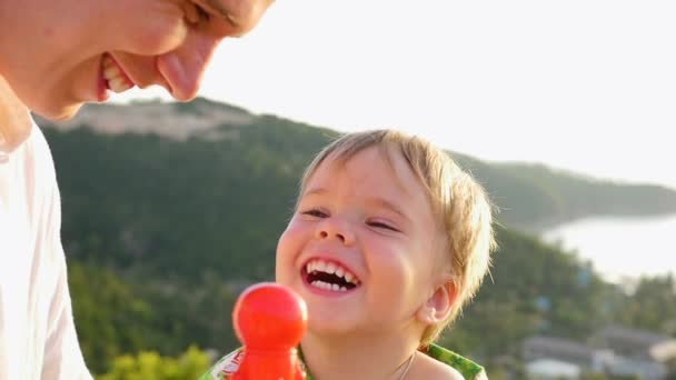 De man met het kind is leuk spelen, lachen. Close-up — Stockvideo