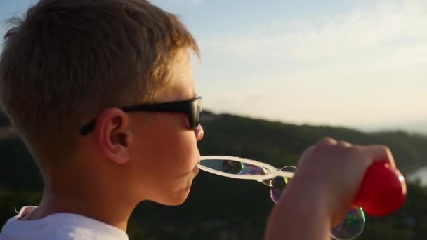 Der Junge macht Seifenblasen. Nahaufnahme. Panoramablick — Stockvideo