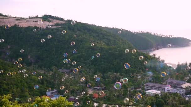 Gelembung sabun terbang di atas laut dan pegunungan. tampilan panorama — Stok Video
