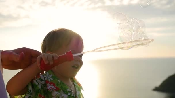De jongen en de vader is het maken van zeepbellen. Close-up. Panoramisch uitzicht — Stockvideo