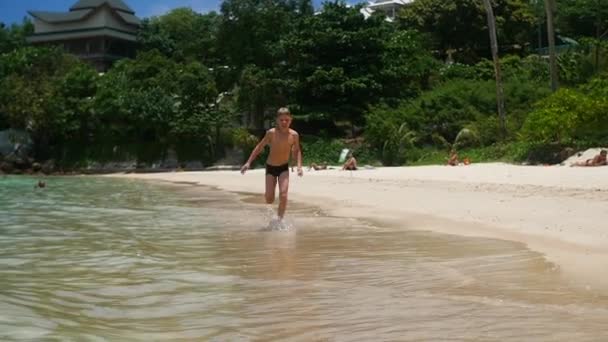 The happy child having fun runs on the shore of a tropical sea — Stock Video