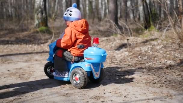 Un niño feliz montando un coche eléctrico — Vídeos de Stock