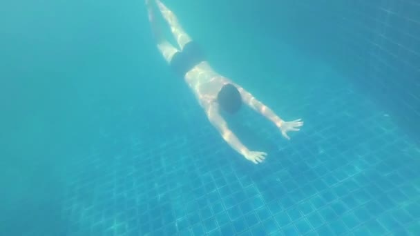 Šťastný chlap plave s radosti pod vodou v bazénu — Stock video