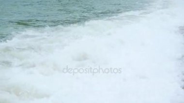 Çocuk sahilde yatıyor ve dalgalar büyük deniz banyo