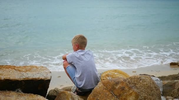 THAILAND. child sits on the seashore and looks out into the distance — Stock Video