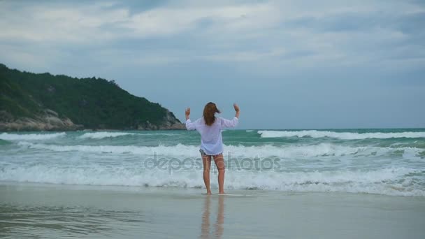 Une jeune fille marche le long du rivage de la plage — Video