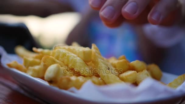 Hand picks up the fried potatoes from the plate. blurred, closeup. — Stock Video