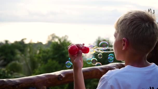 Ten kluk dělá mýdlové bubliny. Panoramatický pohled. Closeup. — Stock video