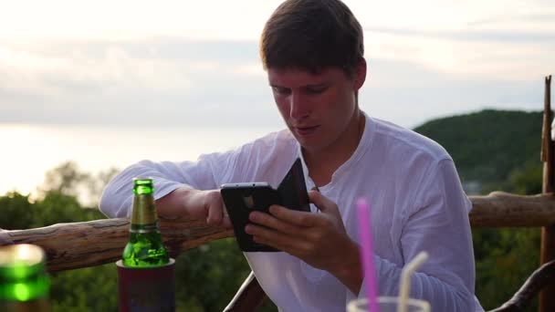 De man zit op de bar en sms in de cel te typen. Panoramisch toegangscode — Stockvideo