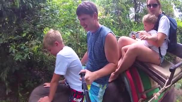 Phangan, THA. Familjen rida på elefanter i den tropiska skogen — Stockvideo