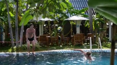 bir adam ve bir çocuk havuzu top oynarken. Spor açık havada