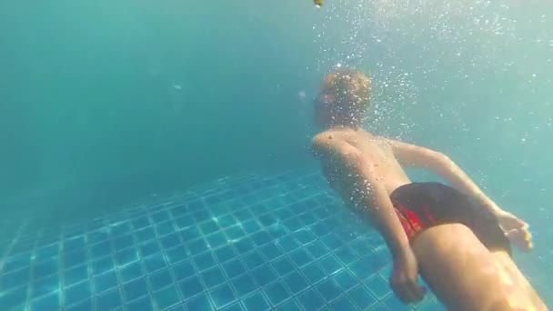 Niño feliz nada con disfrute bajo el agua en la piscina — Vídeo de stock