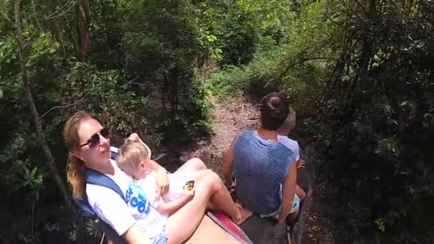 PHANGAN, TAILANDIA. La familia que monta en elefantes en el bosque tropical — Vídeo de stock