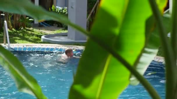 Un chico y un niño jugando a la pelota en la piscina. deportes al aire libre — Vídeo de stock