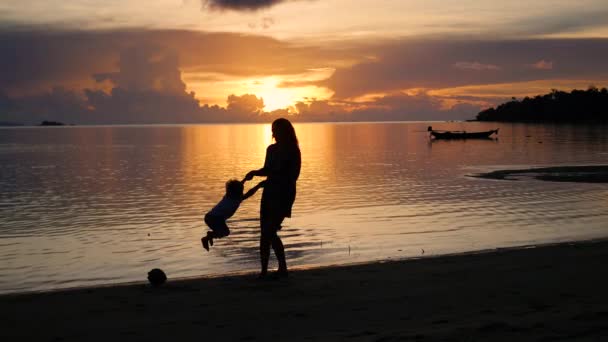 Chica con niños ir a pasear y jugar en la playa durante el atardecer — Vídeo de stock