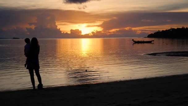 Meisje met kinderen gaan op wandelingen en spelen op het strand tijdens zonsondergang — Stockvideo