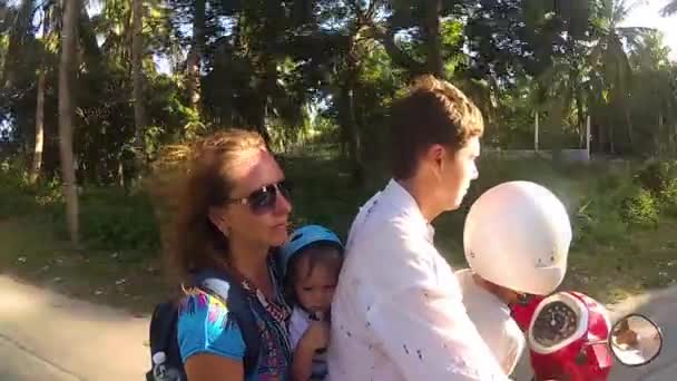 Familia feliz montando una motocicleta en los trópicos. Un día soleado brillante. PHANGAN, TAILANDIA — Vídeo de stock