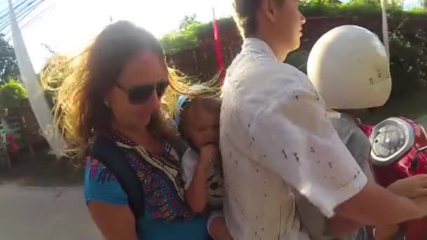 Familia feliz montando una motocicleta en los trópicos. Un día soleado brillante. PHANGAN, TAILANDIA — Vídeo de stock