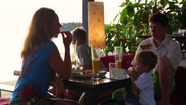 De familie is dineren in het restaurant op het strand. — Stockvideo