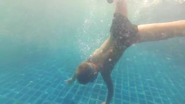 Niño feliz nada con disfrute bajo el agua en la piscina — Vídeo de stock