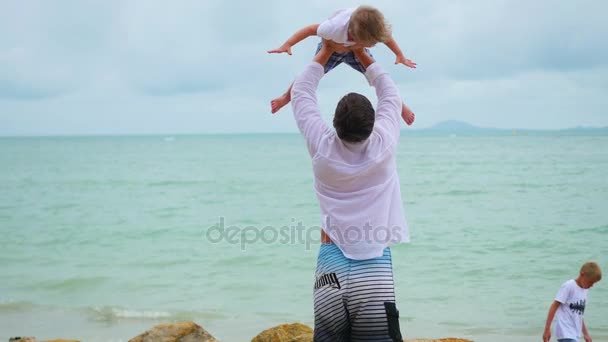 Bir çocuk deniz kıyısı üzerinde tutan genç bir adam. Mutlu bir aile — Stok video