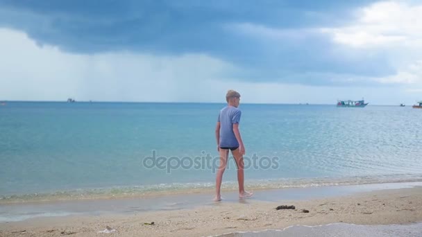Το αγόρι που πηγαίνει κατά μήκος της ακτής της θάλασσας — Αρχείο Βίντεο