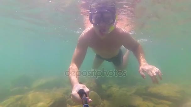 Il ragazzo si bagna in mare con i pesci. Immersioni subacquee in maschera. PHANGAN, THAILANDIA . — Video Stock