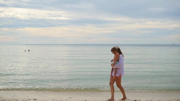 Mädchen mit Kind gehen bei sonnigem Wetter spazieren und spielen am Strand — Stockvideo