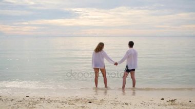 Kıyı çalışan el ele tutuşarak mutlu bir aile. Su sıçramalarına oluşturma çalıştırmak için