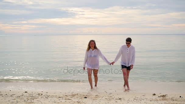 Щаслива сім'я тримає руки біжить уздовж берега. Щоб бігти у воді створюючи бризки — стокове відео