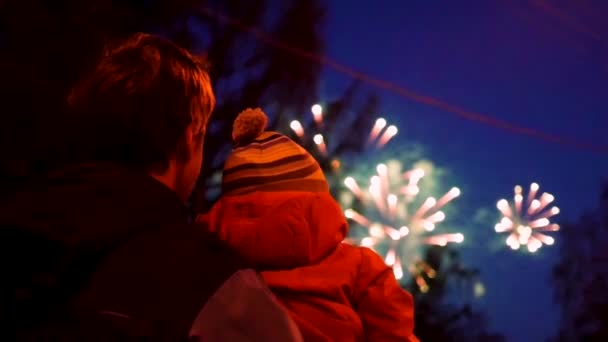 Familie schaut zum Himmel beim Feuerwerk. der Nachthimmel in Lichtern — Stockvideo