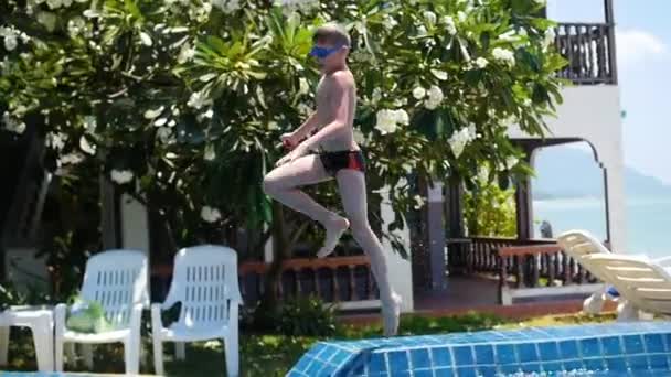 Kid hrát míč v bazénu. sportovní Outdoor. Skočit do bazénu s tryskající — Stock video