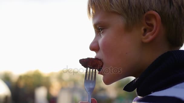 Дитина їсть барбекю на свіжому повітрі. крупним планом — стокове відео