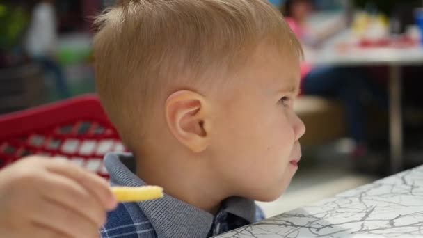 El niño come papas fritas en primer plano de comida rápida — Vídeo de stock