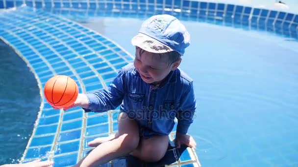 Małe dziecko jest grać w piłkę w basenie. Sporty na wolnym powietrzu. — Wideo stockowe