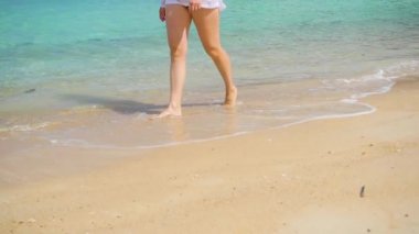 genç bir kız plaj sahil yürür. Ayak portre