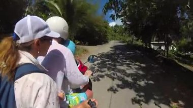 mutlu bir aile tropikal bir motosiklet binme. Parlak güneşli bir günde. Samui, Tayland