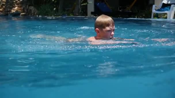 Щаслива дитина з задоволенням плаває в басейні — стокове відео
