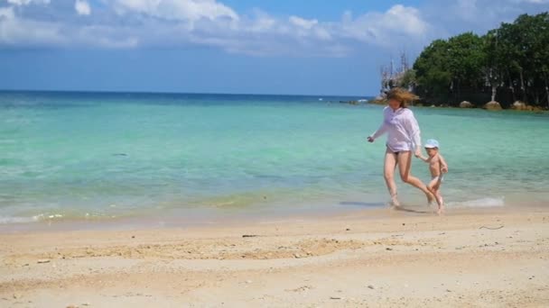 Chica con niño ir a pasear y jugar en la playa durante el día soleado — Vídeo de stock