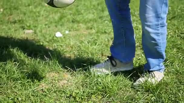 El tipo juega con la pelota en el campo, pateando la pelota con el pie. Deportes al aire libre. Fútbol — Vídeo de stock