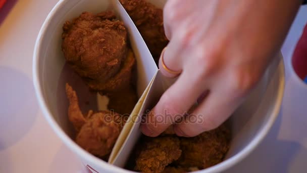 De close-up hand neemt een stuk gebakken kip op de schotel. Fast-food restaurant — Stockvideo