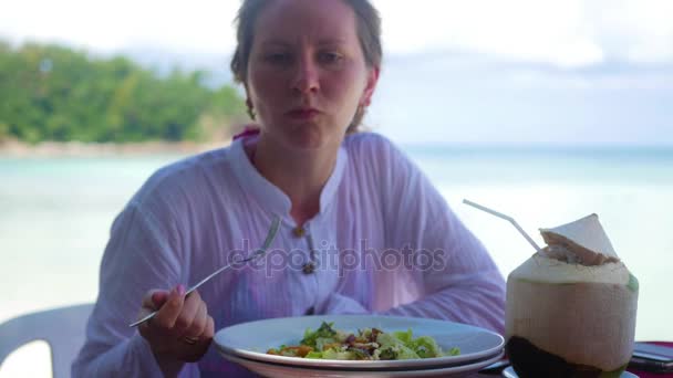 Das Mädchen speist im Restaurant am Strand. — Stockvideo