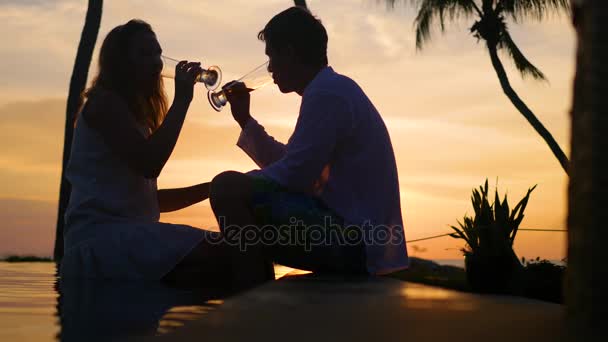 Homem e mulher bebendo vinho no pôr do sol da praia.Noite romântica para dois — Vídeo de Stock