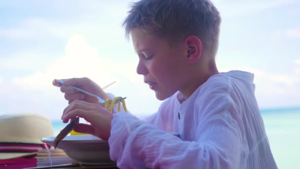 Młody chłopak jest jedzenie na tarasie. na zewnątrz. Dania kuchni włoskiej — Wideo stockowe