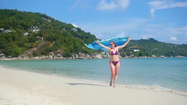 Молодая девушка с парео на берегу пляжа. Тропический остров, теплый летний ветер — стоковое видео
