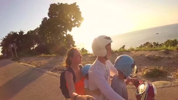 Boldog család lovaglás egy motorkerékpár a trópusokon. Egy ragyogó napsütéses napon. Phangan-sziget, Thaiföld — Stock videók