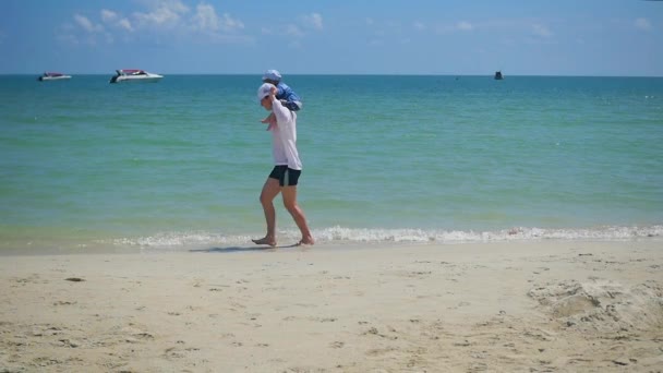 Bonne famille avec des enfants marchant sur la plage de sable fin. Île tropicale, par une chaude journée — Video