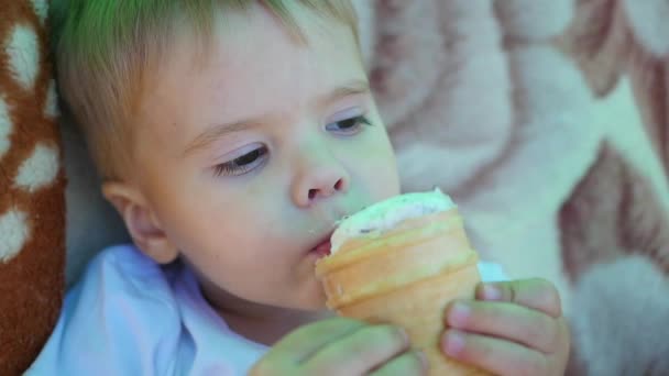 El niño come una taza de helado de gofre en primer plano — Vídeo de stock