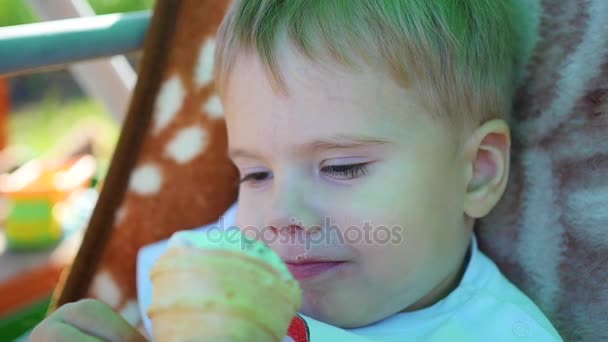 El niño come una taza de helado de gofre en primer plano — Vídeo de stock
